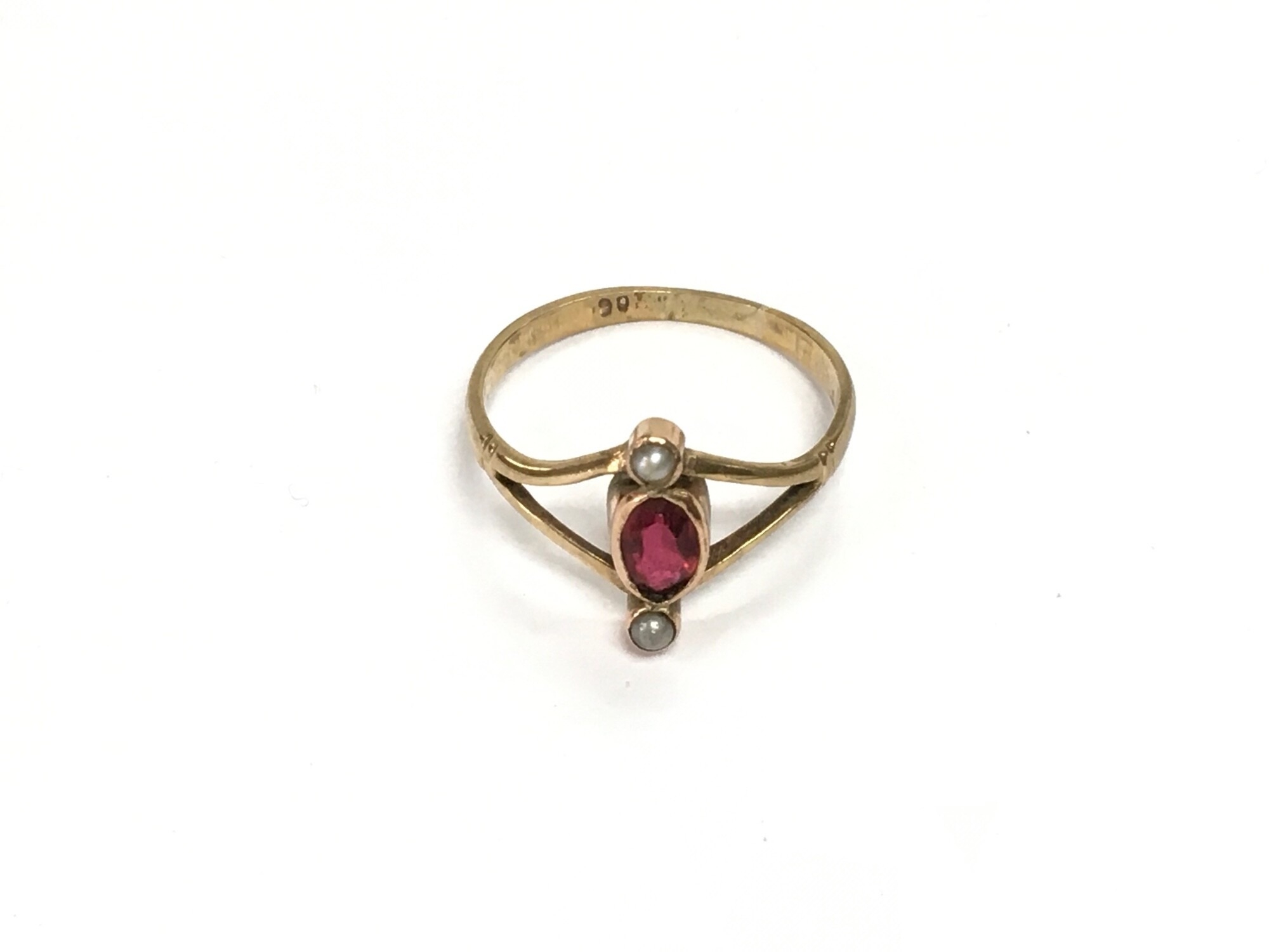 An Edwardian gold ring set with a garnet flanked by two seed pearls, approx 1.5g and approx size N.