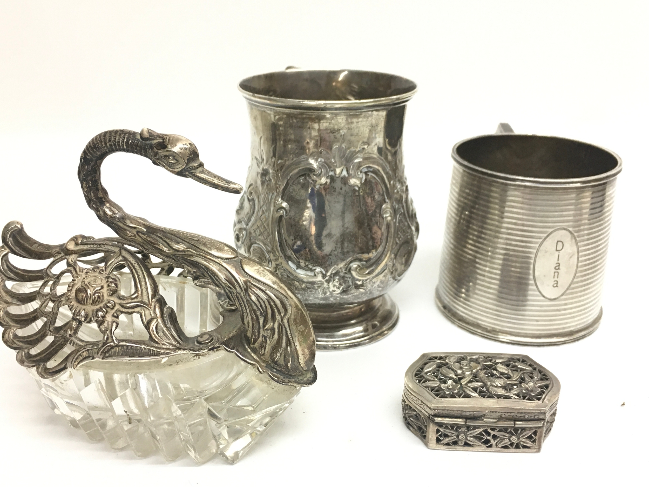 Silver collection including two mugs Mappin and Webb 1933 125 grams and Robert Harper christening mug 1887 114 grams, small cricket box, glass and silver swan ornament. 515g total weight