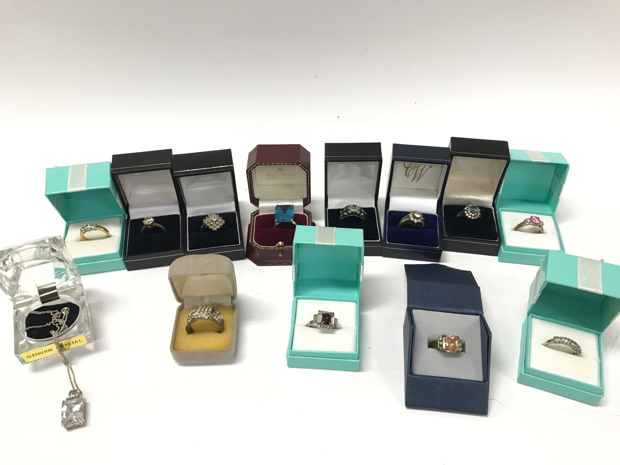 A collection of silver and other rings including a silver necklace.
