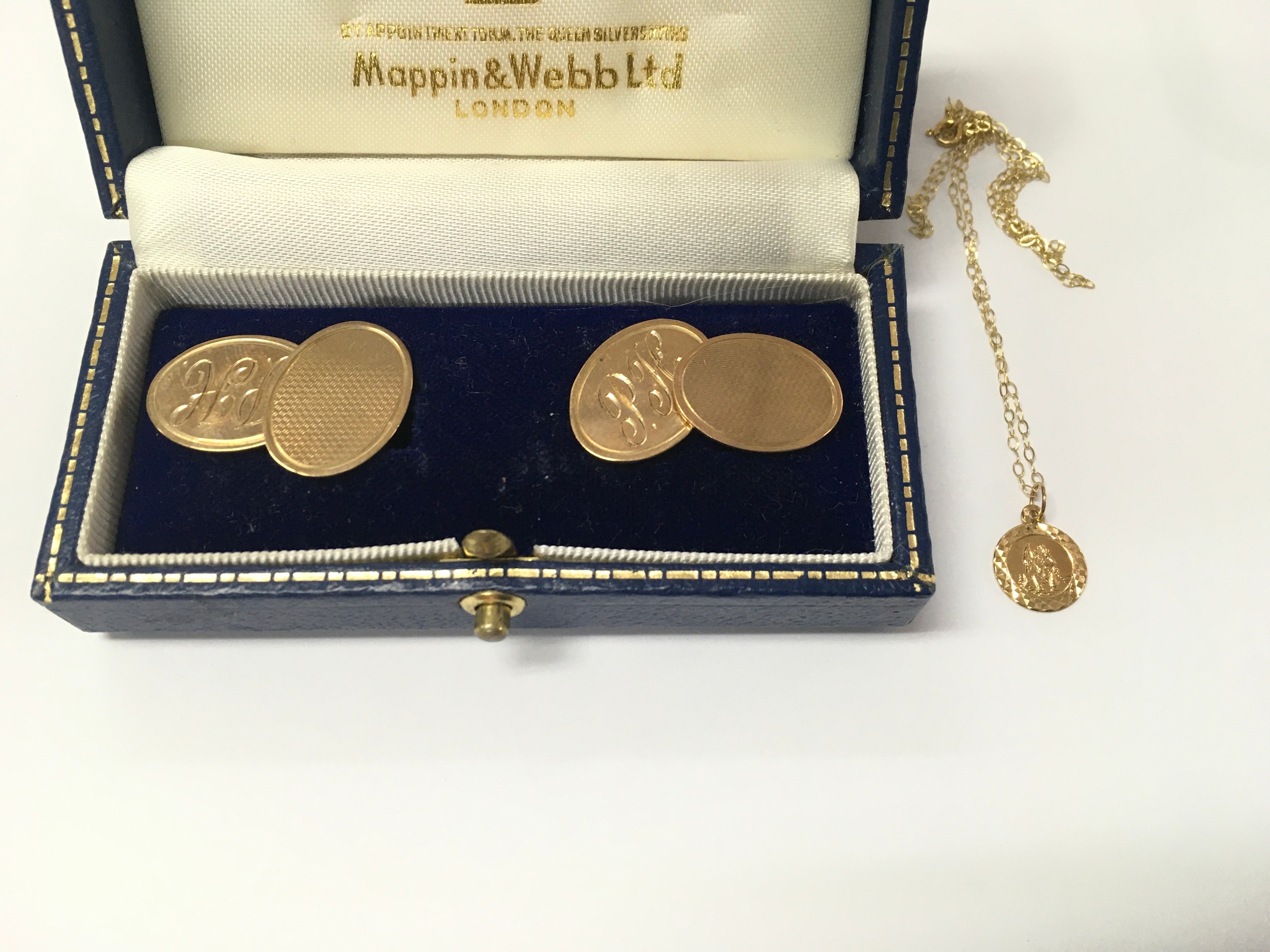 A pair of 9ct gold cufflinks together with a 9ct gold St Christopher and chain. 8.2g total.