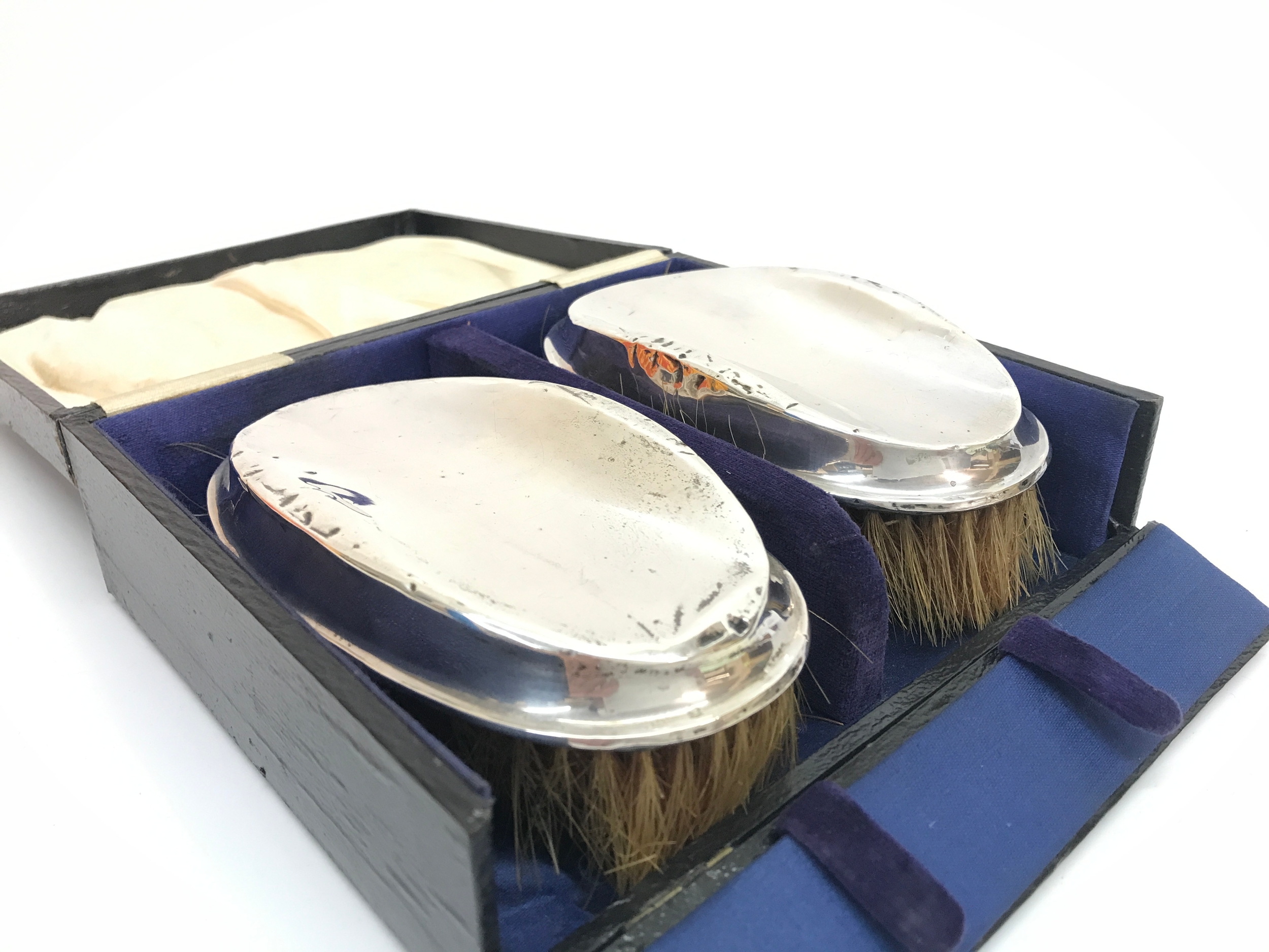 Two cased silver hallmarked brushes. 14cm wide. 290g total weight