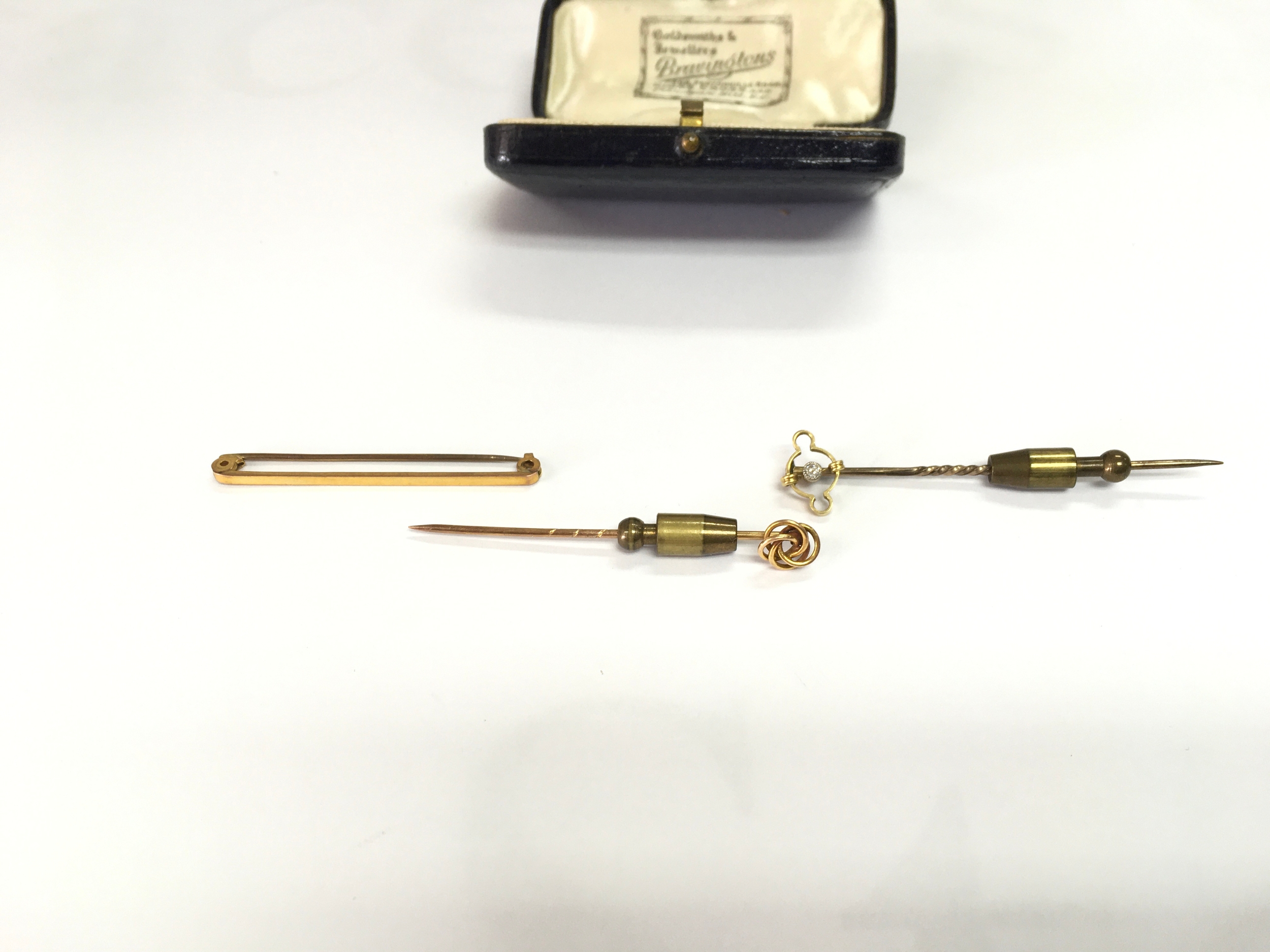Two tie pins and a 9ct bar brooch. 6.7g total.