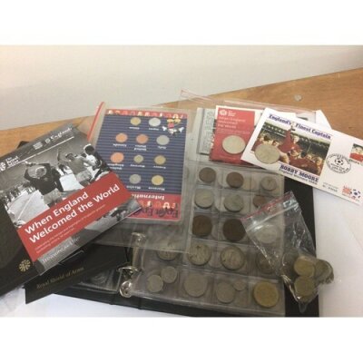 A box containing mixed coins used circulated and an album of coins. 