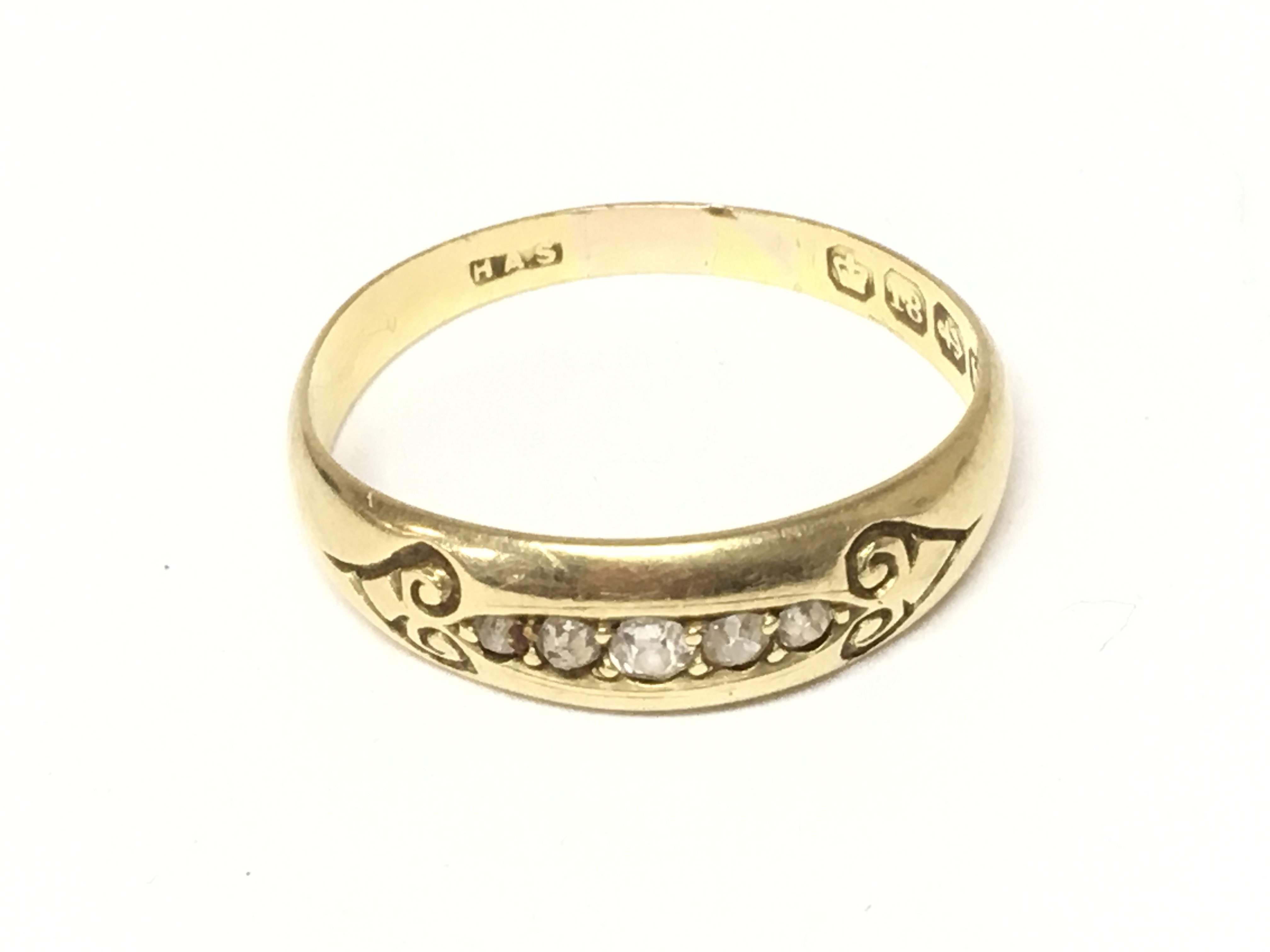 An 18ct gold ring set with a row of small diamonds. Size Q 1/2 and 3.08g Postage A