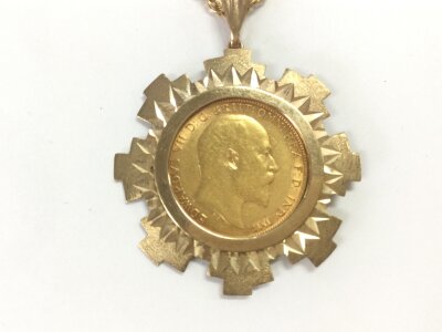 A 1910 half sovereign in 9ct mount and chain.
11.10g