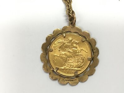 A 1915 full sovereign with 9ct mount and chain.