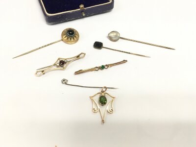 A collection of assorted vintage brooches and stick pins.