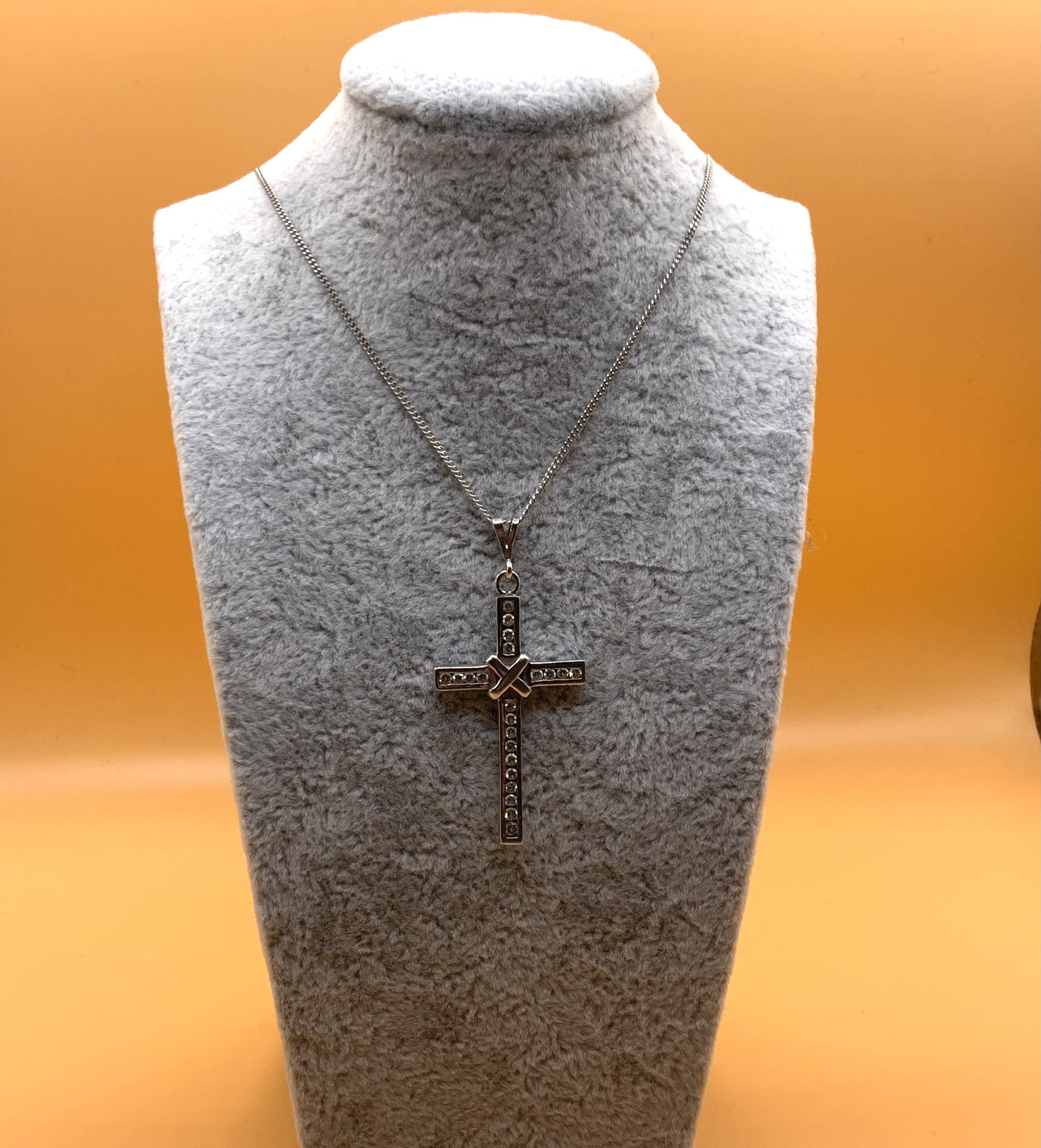 A 9ct gold and Chanel set diamond cross with 9ct gold chain. (A)