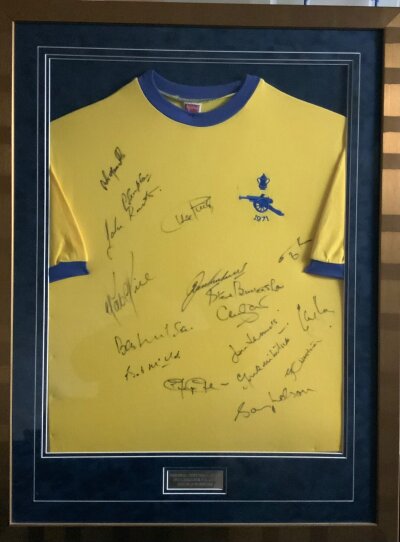Arsenal 70/71 Double Winners Signed Framed Football Shirt: Stunning framed yellow short sleeve replica shirt in attractive gold 38 x 27 inch frame. Genuine autographs x 17 to include Kelly Rice George Nelson Marinello Sammels McNab Radford McLintock Wilson manager Graham and coach Burtenshaw.