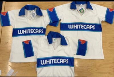 1982 Vancouver Whitecaps Brand New Football Shirts: Three kids sizes original Vancouver Whitecaps shirts brought back by John Wile when he left them in 1982. Two still have tags on which have Admiral to one side and NASL to the other. Excellent for 42 years old. (3)