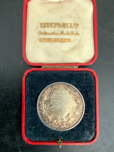 1923 Shot Put At Stamford Bridge Boxed Medal: Silver hallmarked medal in original Vaughtons medal box. Won at Chelseas football ground in July 1923 for the Amateur Athletics Association with AAA to box. Medal is described as putting the 16lb weight which is shot put.