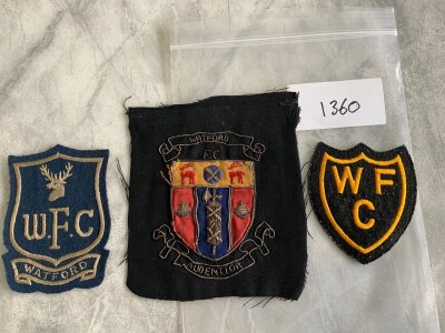 Watford 1950s + 1960s Players Cloth Badges: Removed from either football shirts or blazer badges. Blue WFC Watford badge with Hart to top, WFC black badge with yellow border and writing plus a very old Watford badge removed from black blazer or shirt with the Latin word Audentior which is embroidered with a wire feel. Rare. (3)