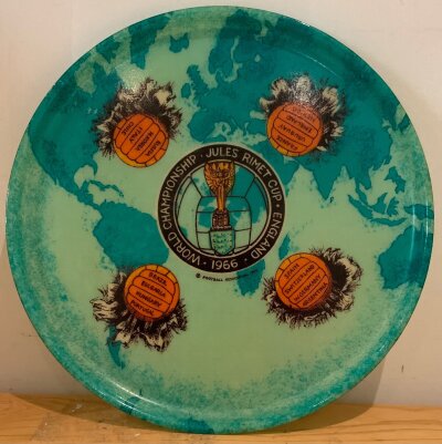 1966 World Cup Football Tournament Tray: Large 14 inch plastic green tray featuring in the middle the Jules Rimet trophy and the words Jules Rimet Cup 1966 World Championship. The rest of the tray has four footballs all with 4 participating teams. Nice item.