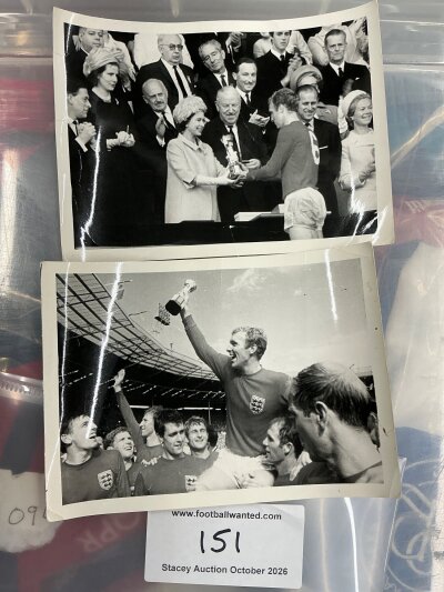 1966 World Cup Bobby Moore England Football Press Photos: 2 5 x 4 inch black and white photos of Bobby. One receiving the cup from the Queen and won celebrating with team mates. Whilst these small photos are from the press they do not have stamps to rear. (2)
