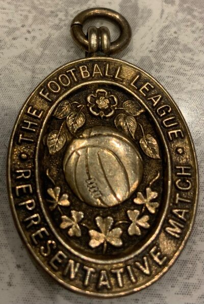 1956 Albert Quixall Manchester United Football League Medal: Awarded to Quixall for playing in the match on 19 September 1956 for The Football League v The Football League Of Ireland in Dublin. Lovely medal with front stating The Football League Representative Match. Reverse has match details, hallmark and Vaughtons stamp. Quixall scored with all 3 England goals coming from Man Utd players with Violet and Taylor getting the others in the 3-3 draw.