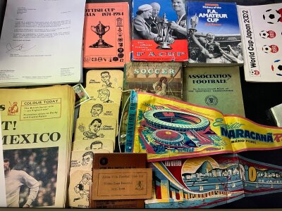 Football Memorabilia Box: Books on the history of the FA Cup, Amateur Cup, Scottish Cup, letters on club headed paper, World Cup 2002 memorabilia, Aston Villa early 60s beer mats and 58/59 season ticket,
, tea towels, Brazilian pennants, Mexico 1970 pre tournament newspapers, photos, Cardiff memorabilia including 2 x 1954 press photos v Peterborough, Irish Linen t towels, flags, cricket items and more. Instructions to sell.