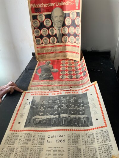 Manchester United Football Memorabilia Boxes: Superb original large calendars in the form of a large poster from 1968 1969 + 1970. From 1968 European triumph there are two different pennants, boxed coin, magazine and a large Coffer pin badge. There are Typhoo tea cards and 3 68/69 Supporters Club newsletters.