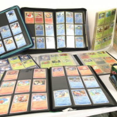 A collection of modern pokemon cards, in 7 albums and a tin.