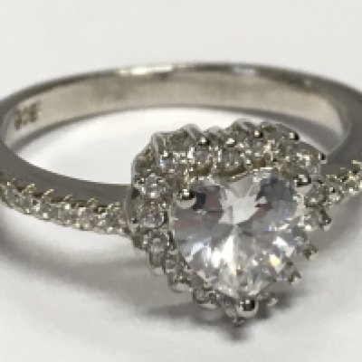 A silver ring set with a central white heart shaped cubic zirconia , with a halo of CZs and CZ shoulders. Size P. 