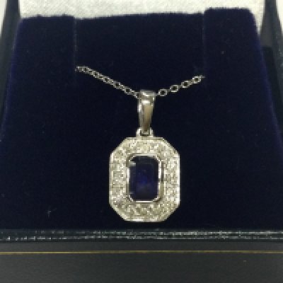 An 18ct white gold step cut sapphire and RBC diamond pendant on a 18ct white gold chain , boxed. Sapphire 0.70ct diamonds 0.24ct. 2.64g total weight. 