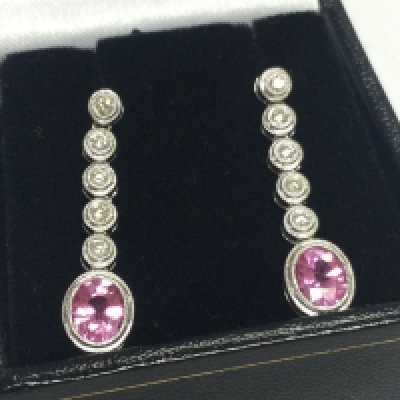 Pair of 18ct white gold drop earrings set with oval pink sapphires and RBC diamonds with millgrain detailing. Boxed. Pink sapphires 1.00ct approx. Diamonds 0.25ct approx . Total weight 4.3G 