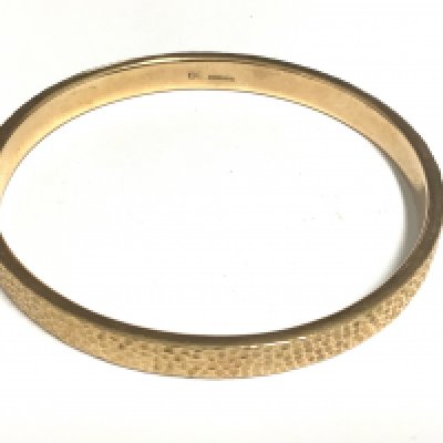 A 9ct gold bangle with hammered finish. 12.6g