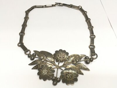 A sterling silver necklace with floral design.