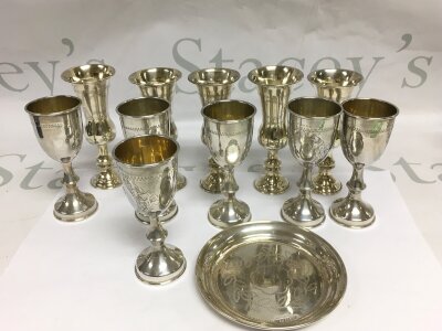 A collection of silver Judaica Kiddush cups and a small dish.