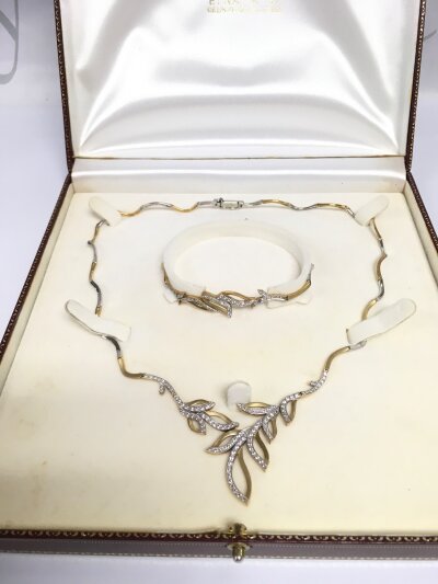 A boxed 14ct gold two tone necklace and matching bangle set with small diamonds, approx total weight 26g.