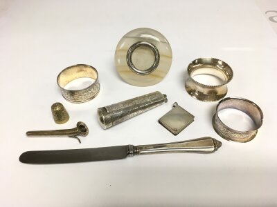 A sm collection of silver items comprising napkin rings, butter knife etc.