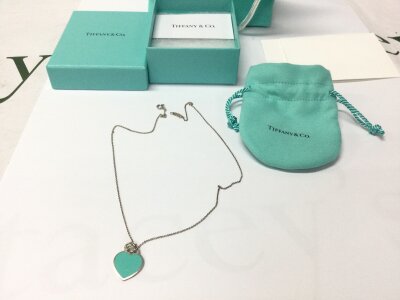A silver Tiffany and Co heart pendant with box.