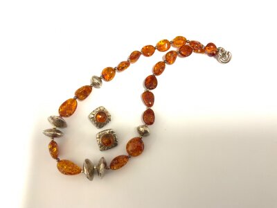 A sterling silver and amber necklace with conforming silver and amber clip earrings.