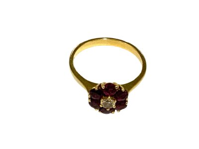 An 18ct ruby and diamond daisy cluster ring, Size N.