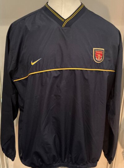 Arsenal 97/98 Player Issue Tracksuit Top: Navy blue Nike long sleeve with yellow trim waterproof tracksuit top. Size XXL with yellow netting inside in excellent condition.