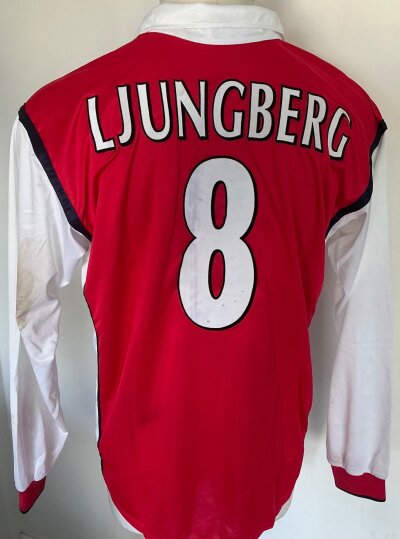 1999 - 2000 Arsenal Ljungberg Match Worn Football Shirt: Long sleeve red Dreamcast shirt with no arm badging ( which is correct ) and number 8 Ljungberg to rear. Worn in match v Nantes in UEFA Cup on 9 12 1999. COA signed by Ljungberg. Whilst shirts are washed there is still mud staining to white sleeve.