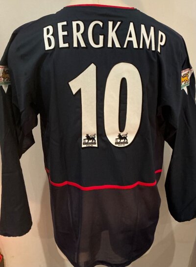 2002 - 2003 Arsenal Bergkamp Match Worn Football Shirt: Blue long sleeve with number 10 Bergkamp to rear and Premier League gold sleeve badging stating Champions 2001 - 2002. Worn in match v Liverpool on 29 1 2003. COA signed by Bergkamp and picture of him wearing the shirt included.