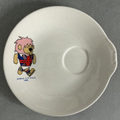 1966 World Cup Willie Saucer: Rare decorative saucer featuring a colourful WC Willie. The reverse has the official FA copyright. Looks like a saucer for a cup but has also been described as an egg cup holder. Excellent. 