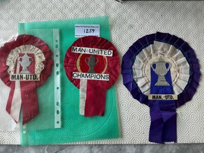 Manchester United 1960s Football Rosettes: Two different standard size red rosettes one stating champions the other stating Man Utd with FA Cup to centre. The other is a larger blue one with FA Cup possibly used in 1968 for the European Cup final as all cups were standard on rosettes. (3)