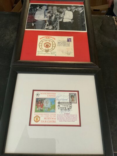 Manchester United Signed Framed FDCs: One signed by Matt Busby underneath a picture of him and players with the European Cup and a further with 3 autographs including a Scanlon and Wood. (2)