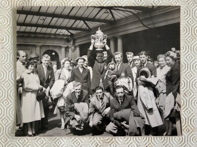 1956 Manchester City FA Cup Winners Press Photo: 10 x 8 inch photo with press stamp to rear and annotations stating the team are at Euston station with the FA Cup. Excellent.