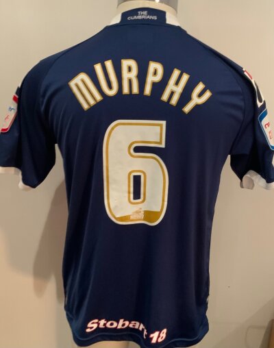 Carlisle 2013 - 2014 Match Worn Football Shirt: Blue and red short sleeve shirt. Number 6 Murphy to rear. Match Worn v Tottenham in the Carabao Cup
