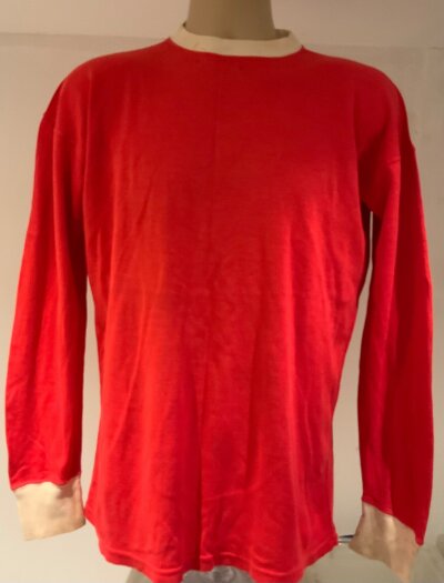 George Best + Denis Law Manchester United Match Worn Football Shirt: Red long sleeve good condition shirt with white trim. Number 8 shirt which has Umbro label still attached which states as used by Real Madrid which is label for match worn shirts 63/64 to 65/66. Very good condition with the odd age stain to white trim. Please note this shirt was gifted by Best to a relative of the vendor who was a friend of Matt Busby at the end of the 65/66 season and could have also been worn by Bobby Charlton David Herd and more often Denis Law who wore this number on 34 occasions this season compared to Best who wore it 5 times. These were the days when a shirt would go back into the kit bag until it looked tatty.