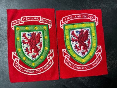 Wales Football Shirt Cloth Badges: Removed from match worn red shirts from 65/66 v Ireland and 60/61 v England with match details embroidered. Attractive items. (2)