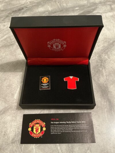 2010 - 2011 Manchester United v Wolves Corporate Gift: Black box with match details to front with match badge inside and badge in the shape of a Man Utd Busby Babes shirt. Card inside relates to the badge. C/W a Halcyon Days Enamel box with a Manchester United trinket box which when open reads presented by Manchester United. Both like new. (2)
