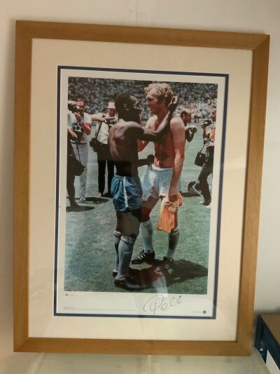 Pele Brazil Signed + Framed Football Print: Limited Edition genuine big blue tube print nicely framed and double mounted. Famous moment captured swapping shirts with Bobby Moore at the 1970 World Cup. Hand signed by Pele. Frame measures 30 x 22 inches.
