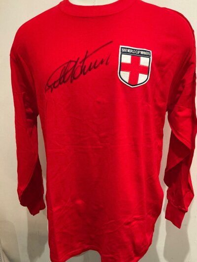 England Geoff Hurst Signed Replica Football Shirt: Red England 1966 World Cup Winners shirt signed to the front with players full signature. Excellent collection reproduction shirt. Comes with COA.