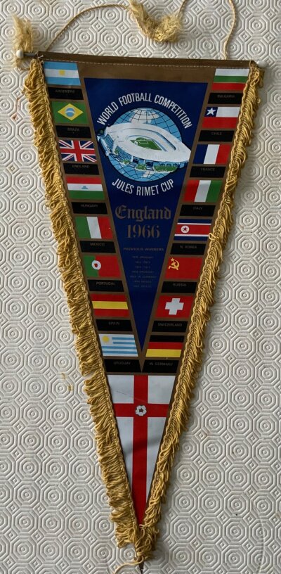 1966 World Cup Football Pennants: Stunning decorative 22 inch pennant with participating countries flags. C/W 5 all different original smaller pennants. Very nice. (6)