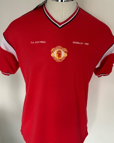 Manchester United 1985 FA Cup Final Football Shirt: Brand new with tags Score Draw brand replica. Red short sleeve in size large with Wembley 1985  FA Cup Final embroidered. C/W older Score Draw used Spain Shirt with number 7 to rear in size XL. (2)