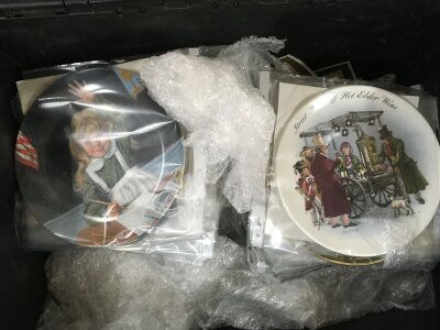 A large collection of assorted collectors plates.