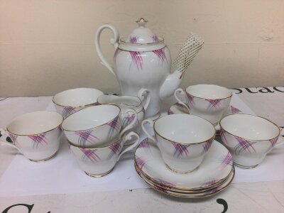 An early 20th century British bone china coffee set with pink and grey on a white ground chip to milk jug otherwise no obvious damage.